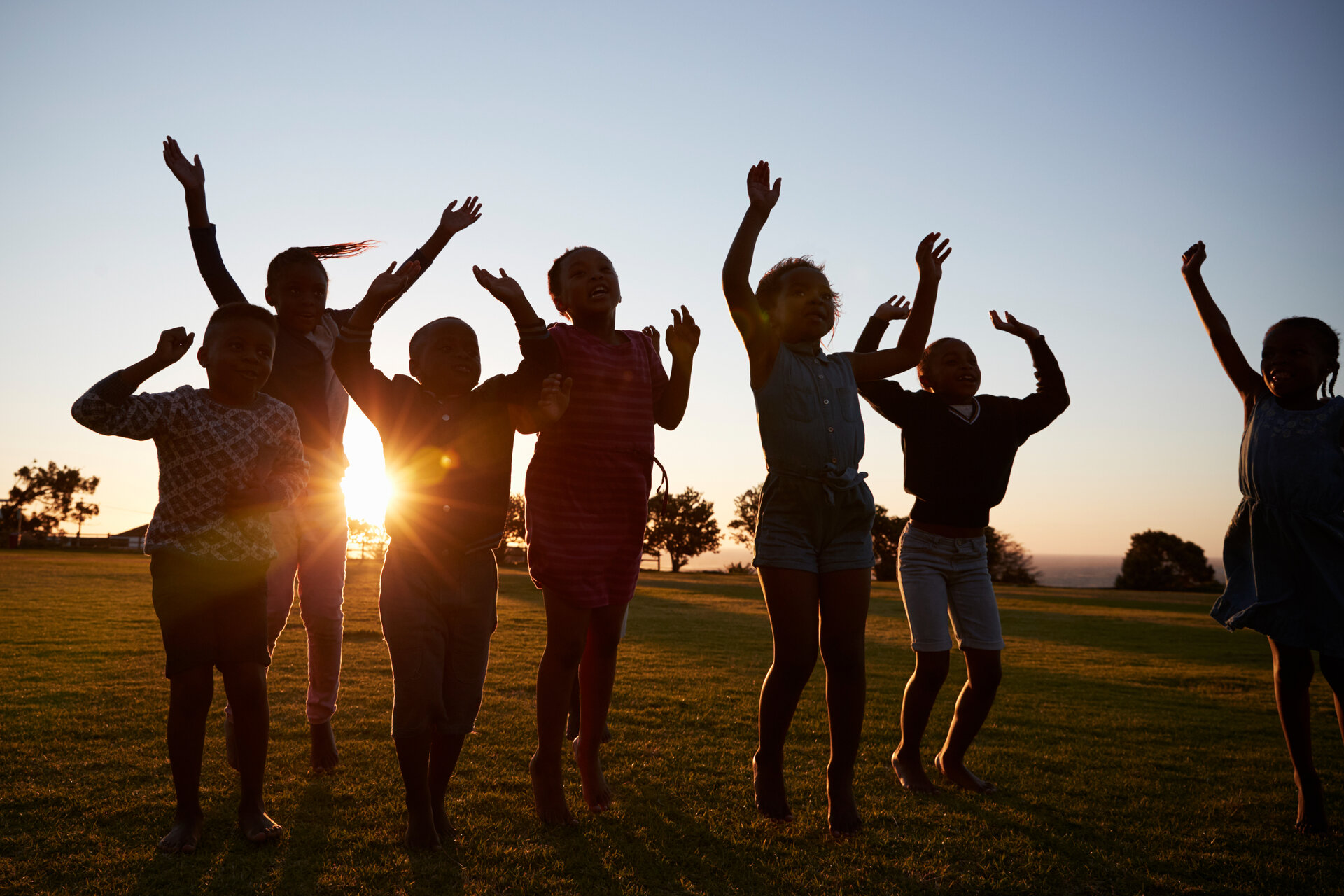 silhouetted-school-kids-jumping-outdoors-at-sunset-P563D2P (1)
